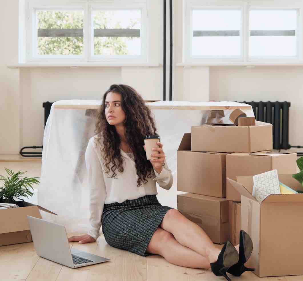 Young businesswoman sitting on the floor before an office move.
