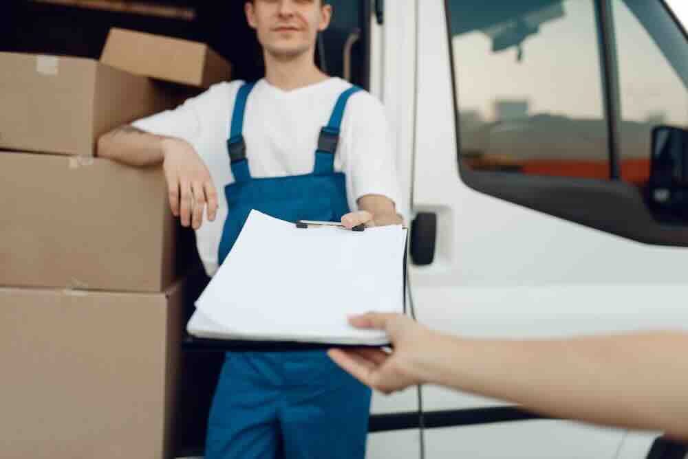 Delivery man in a uniform answering the question about when to pay movers.