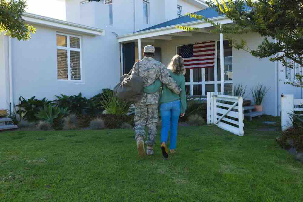 Serviceman and wife walking into a home, representing military moves.