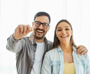 Couple holding keys for a first-time homebuyer move.