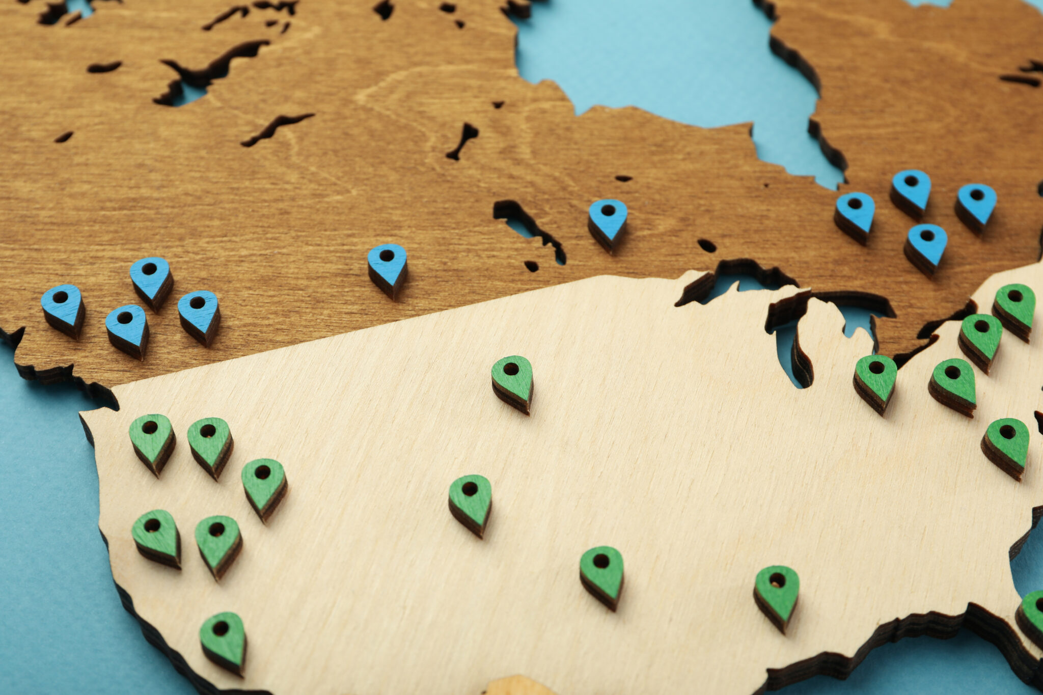 Wooden map with location markers indicating remote employee moving hotspots and remote work relocation trends.