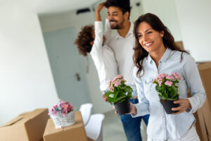 Woman carrying flowers while demonstrating work-from-home moving patterns. 