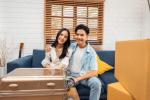 Happy young couple seated on a couch in one of the remote employee moving hotspots. 