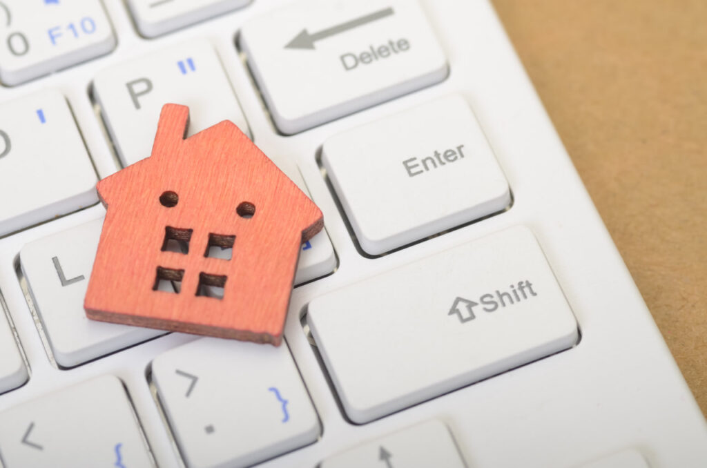  Orange wooden house token on a keyboard which represents online apartment hunting tips with a virtual apartment tour checklist. 