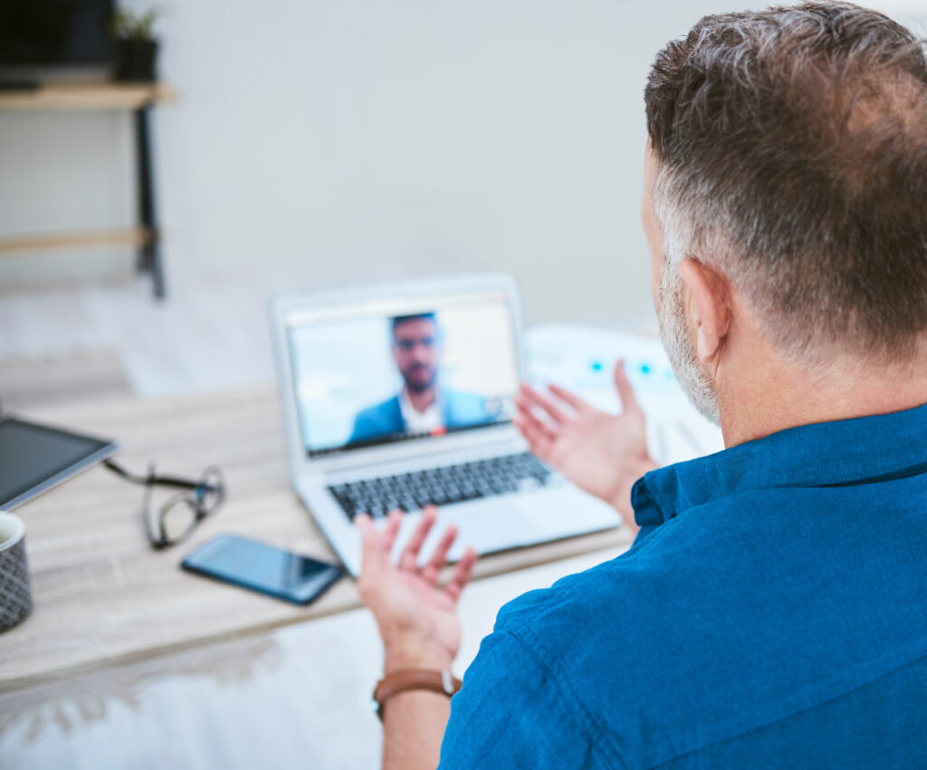 A middle-aged man meeting virtually with a realtor to vet rental home remotely.