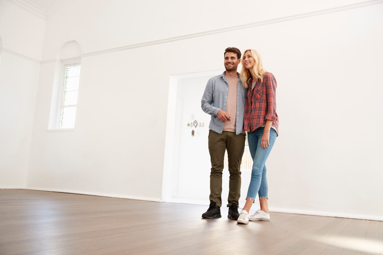 Couple waking into an empty, ready house before movers arrive.