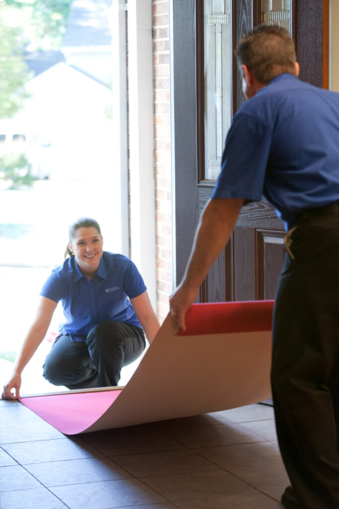 Central Transportation completing moving day prep by covering floors.