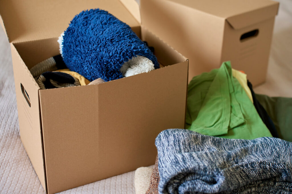 Box filled with items to donate as a “how to save money on a professional move” strategy.