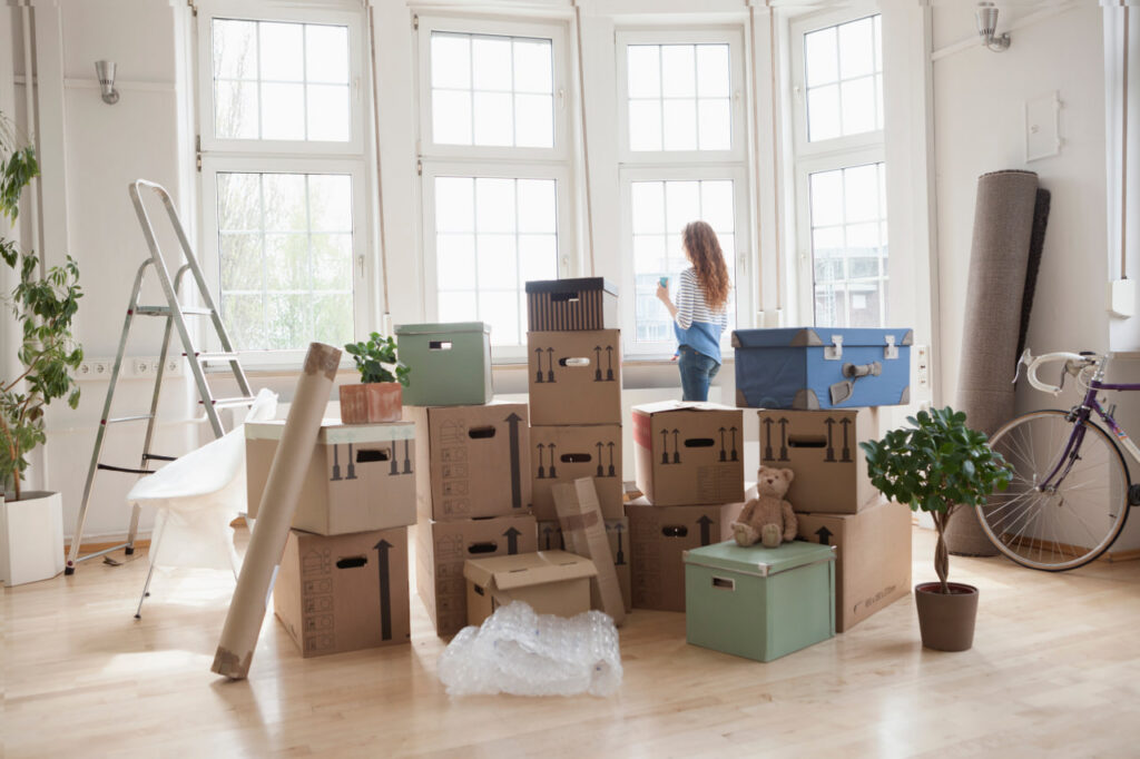 Woman standing in front of boxes packed by antique movers committed to protecting irreplaceable items during a move.
